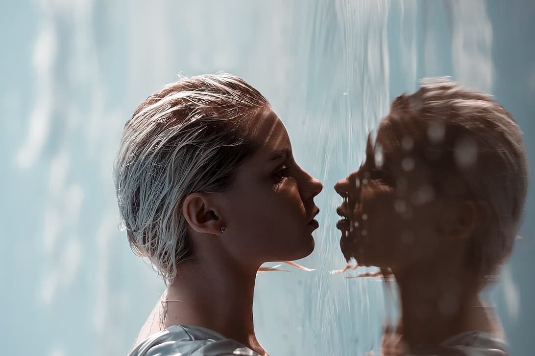 close up of a water surface reflecting a human face, symbolizing human connection to water